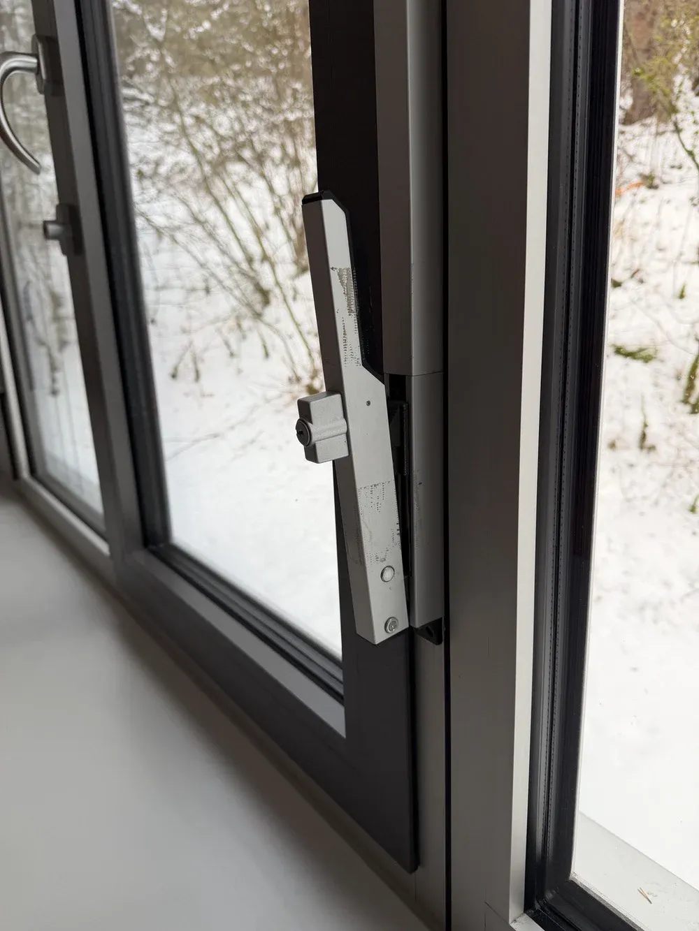 Fensterwartung: Geöffneter Fensterflügel mit Beschlag und Verriegelungszapfen an der Griffseite