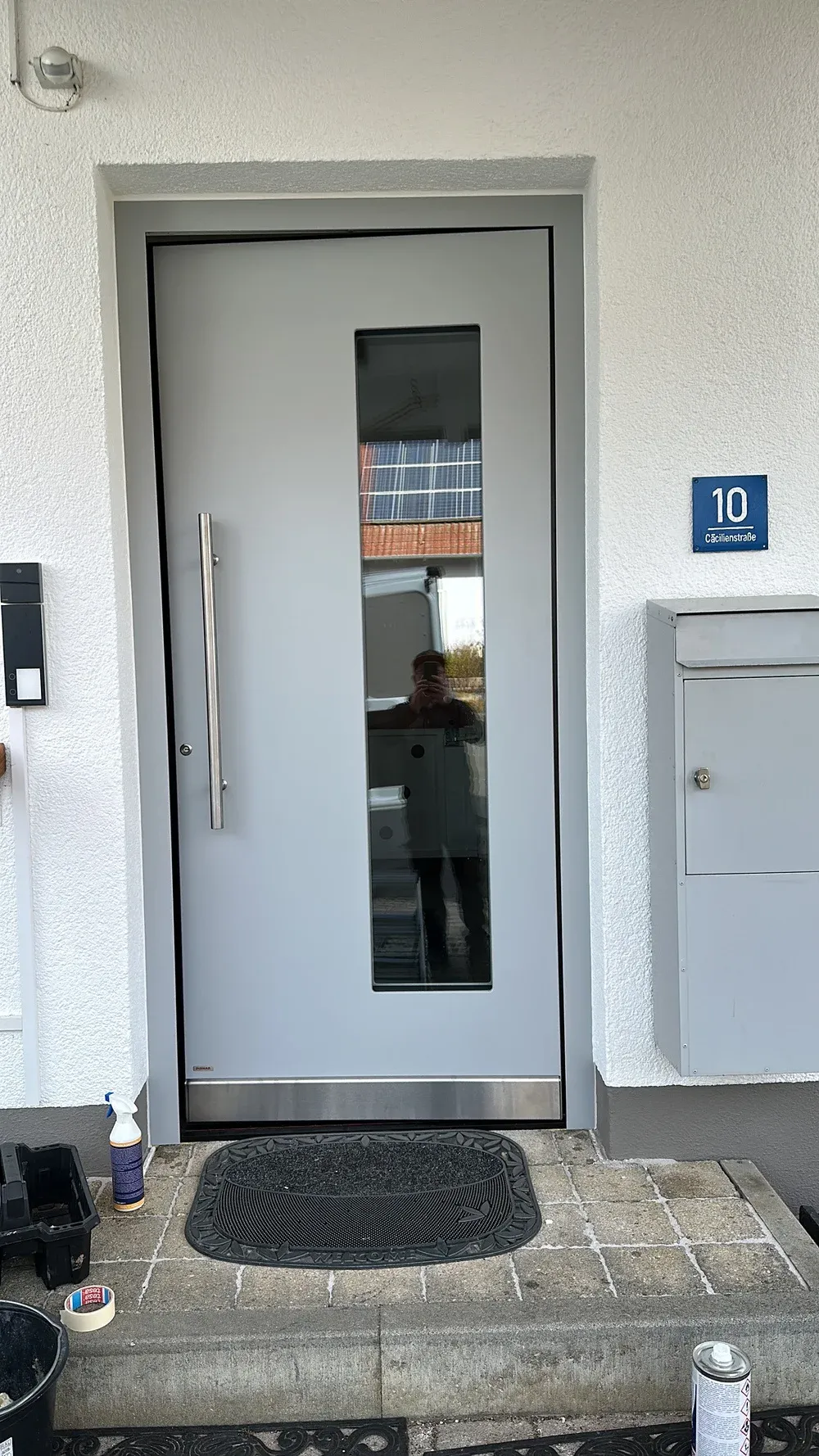 Haustüren: Weiße Haustür mit senkrechtem Lichtausschnitt und Stoßgriff