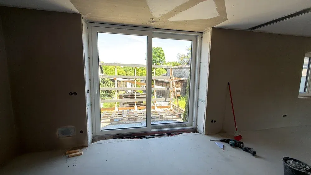 Sanierung: Großes Fensterelement in einem Wohnraum im Rohbau