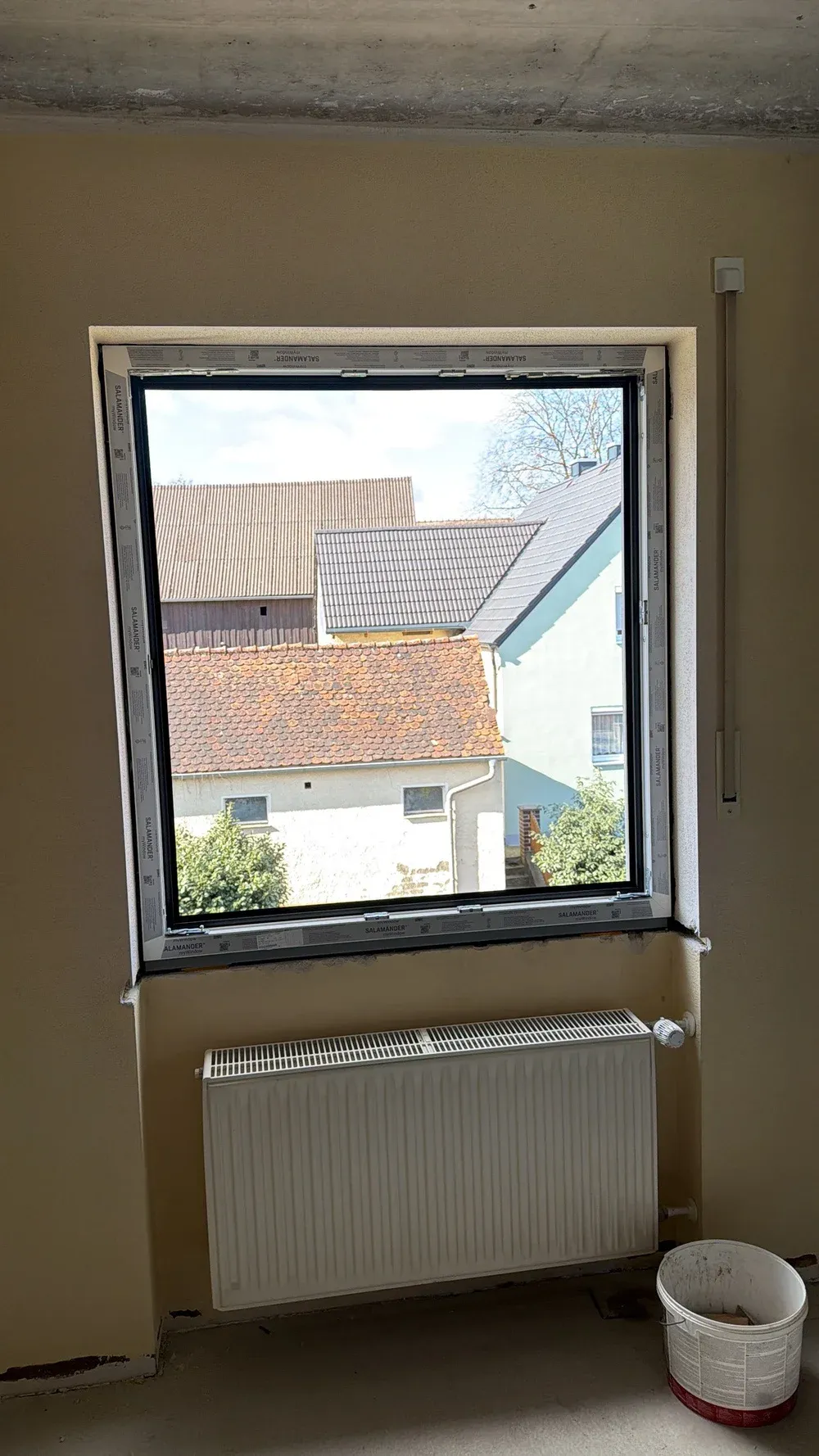 Geöffnetes Wohnraumfenster mit Blick über die Nachbardächer